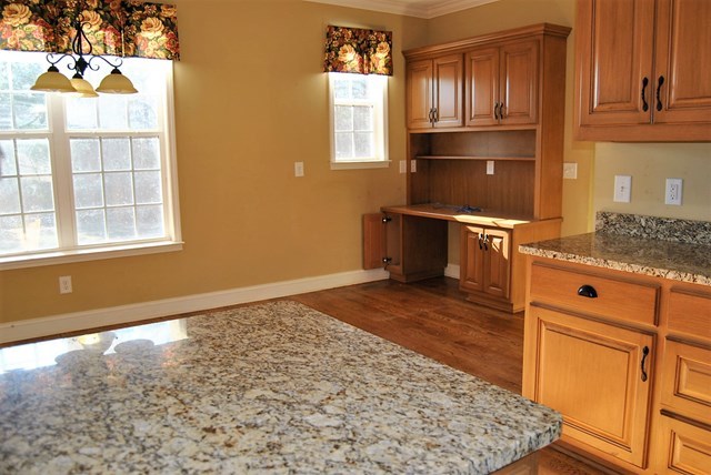 1399 Edge Road Forsyth, GA 31029 - Photo 12 of 31 a kitchen with granite countertop a stove refrigerator and microwave