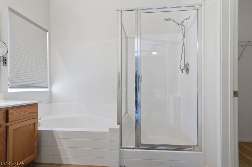 754 Solitude Point Avenue Henderson, NV 89012 - Photo 31 of 38 Relax in this well-appointed bathroom featuring a deep soaking tub and a sleek glass-enclosed shower.