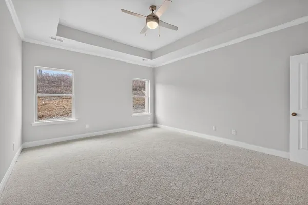 an empty room with windows and ceiling fan