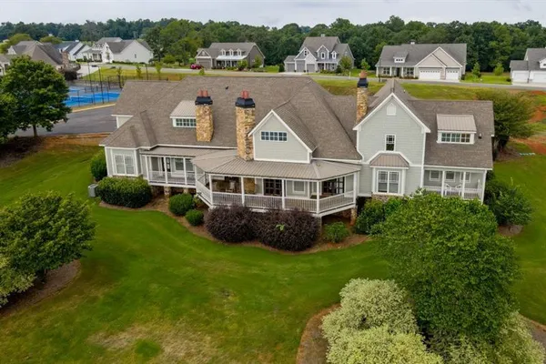 an aerial view of residential house with yard and outdoor seating