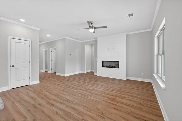 a view of empty room with wooden floor