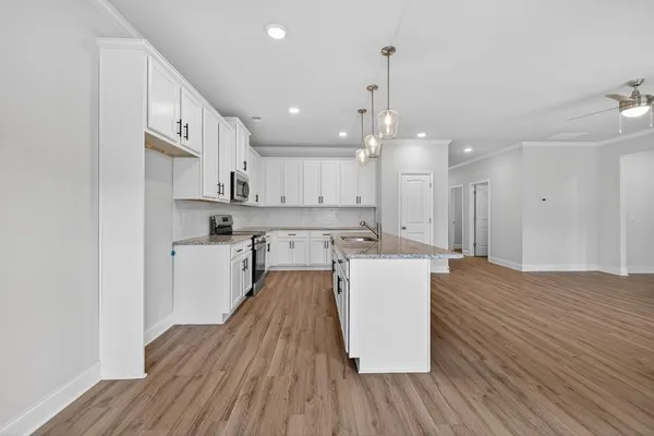 a large kitchen with cabinets wooden floor and stainless steel appliances