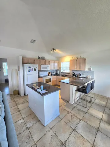 a kitchen with kitchen island granite countertop a sink and a stove