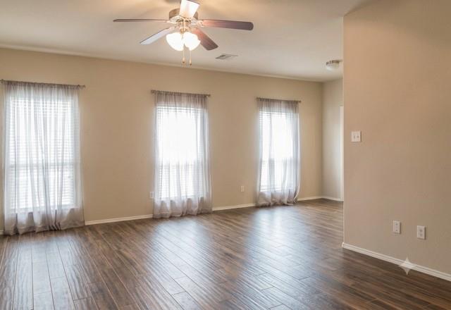 415 Harding Lane Lavon, TX 75166 - Photo 9 of 13 Spacious interior room featuring wood-finish flooring, light tan walls, and multiple windows