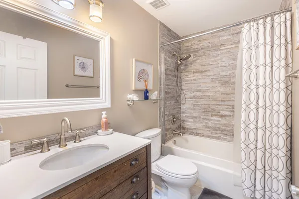 a bathroom with a granite countertop sink toilet and shower