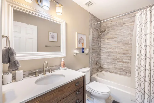 a bathroom with a granite countertop sink toilet mirror and shower