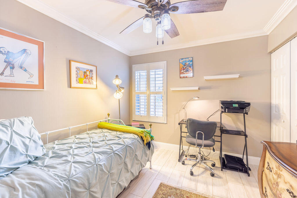 1038 Jeffery Street Boca Raton, FL 33487 - Photo 25 of 47 a bedroom with a bed and a chandelier