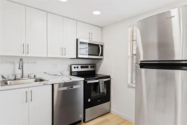 a kitchen with cabinets stainless steel appliances and a sink