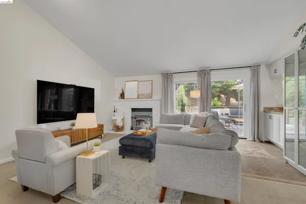 a living room with furniture a flat screen tv and a fireplace