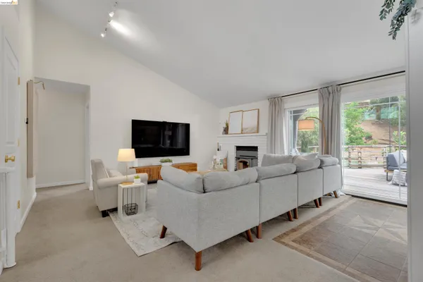 a living room with furniture a flat screen tv and a large window