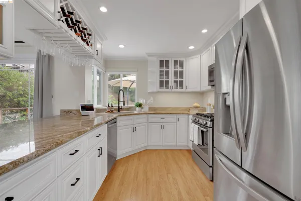 a kitchen with stainless steel appliances granite countertop a refrigerator and a sink