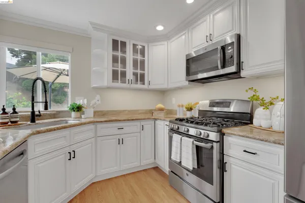 a kitchen with white cabinets and appliances