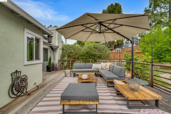 an outdoor sitting area with furniture and wooden floor