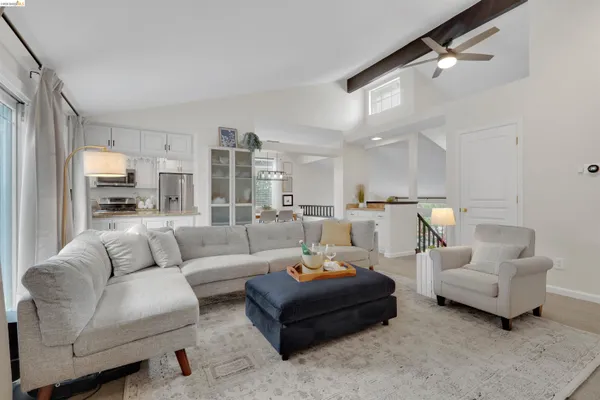 a living room with furniture white walls and a view of kitchen