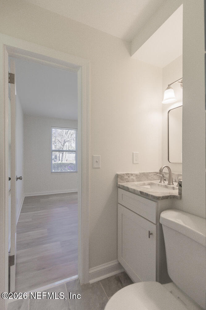 2754 Rainbow Road Jacksonville, FL 32217 - Photo 13 of 25 a bathroom with a granite countertop toilet a sink and a mirror