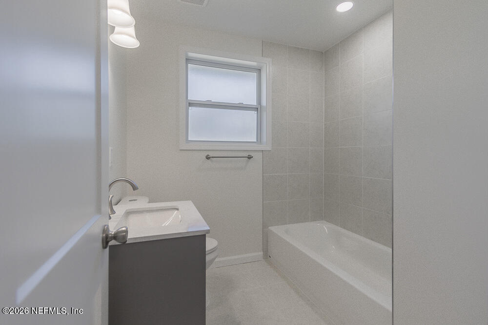 2754 Rainbow Road Jacksonville, FL 32217 - Photo 16 of 25 a bathroom with a tub sink and mirror