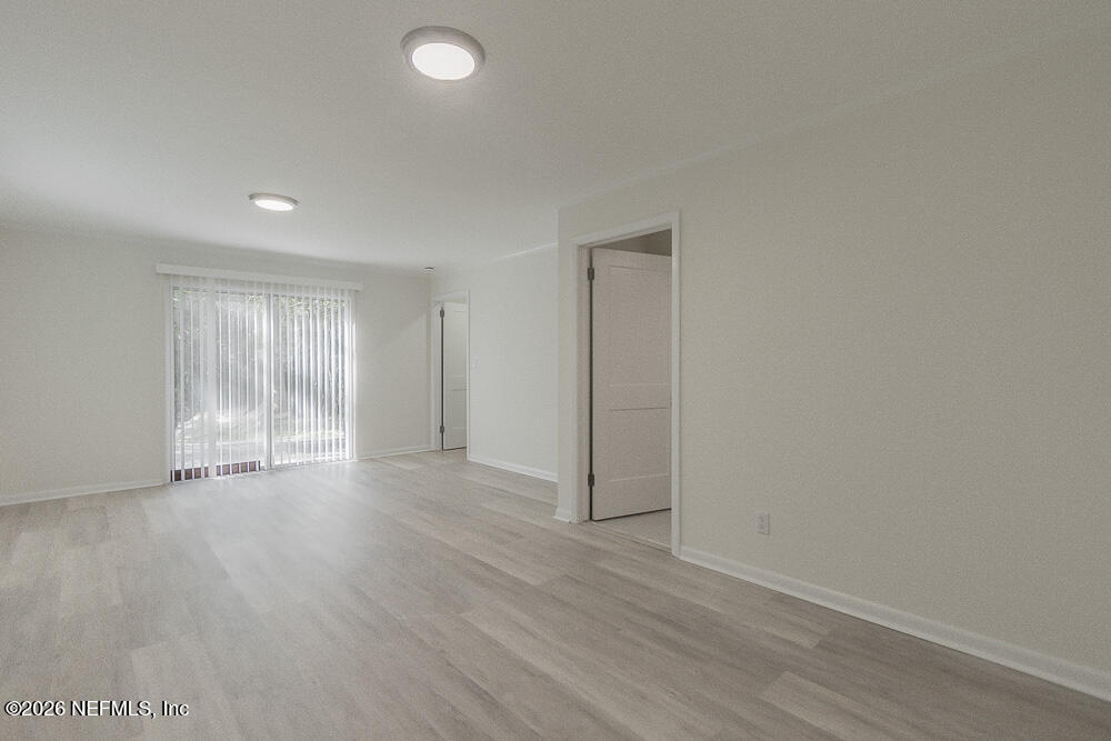 2754 Rainbow Road Jacksonville, FL 32217 - Photo 18 of 25 a view of an empty room with wooden floor and a window