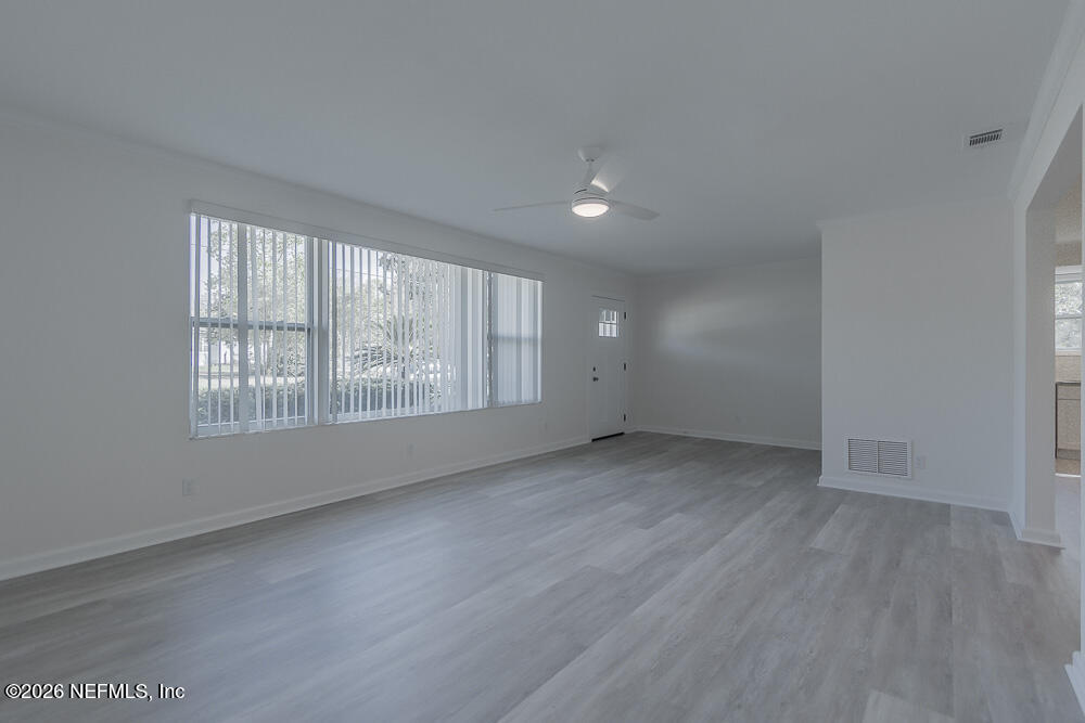 2754 Rainbow Road Jacksonville, FL 32217 - Photo 2 of 25 an empty room with wooden floor and windows