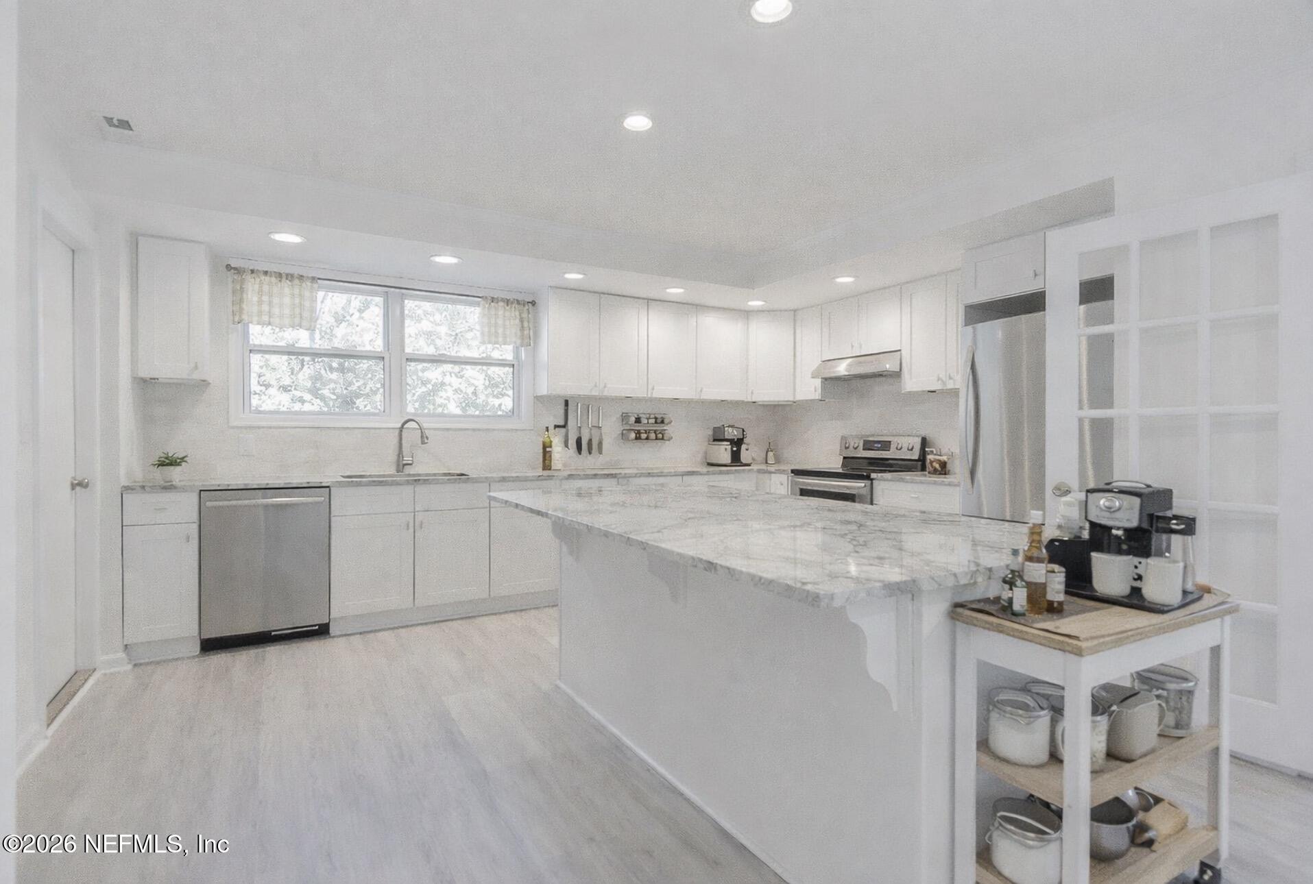 2754 Rainbow Road Jacksonville, FL 32217 - Photo 4 of 25 a kitchen with a sink white cabinets and white appliances