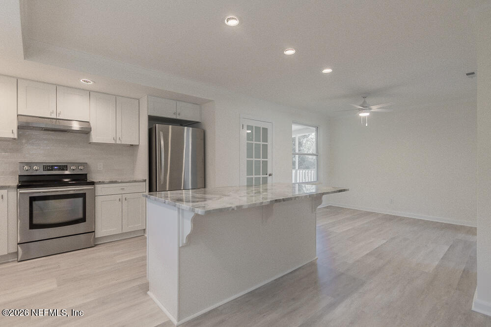 2754 Rainbow Road Jacksonville, FL 32217 - Photo 5 of 25 a kitchen with stainless steel appliances granite countertop a stove and a refrigerator