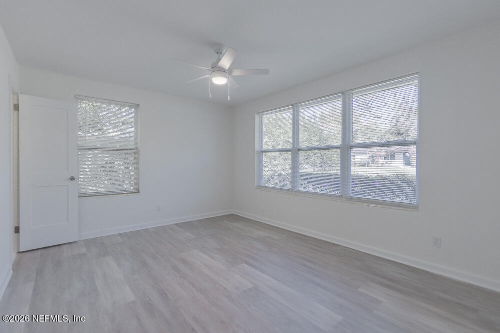 2754 Rainbow Road Jacksonville, FL 32217 - Photo 9 of 25 an empty room with wooden floor and windows