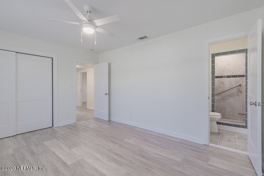 2754 Rainbow Road Jacksonville, FL 32217 - Photo 10 of 25 wooden floor in an empty room with a bathroom
