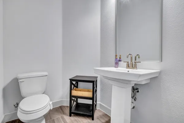 a bathroom with a toilet a sink and mirror
