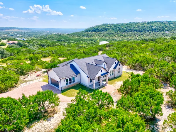 an aerial view of a house with a garden and lake view