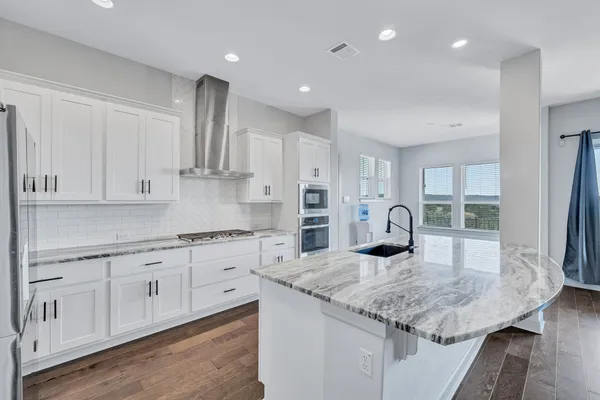 a kitchen with sink stove and cabinets