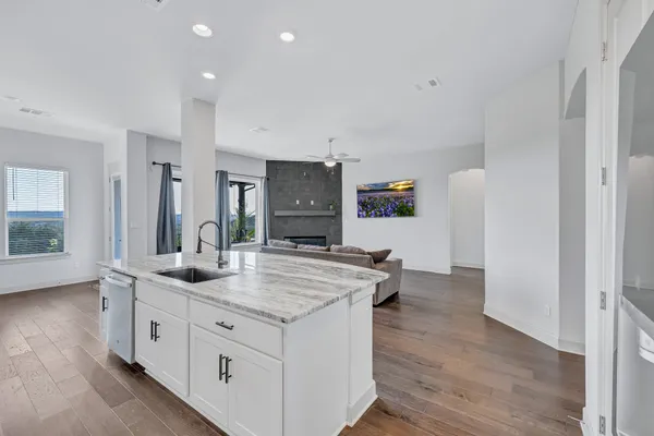 a kitchen with sink stove and wooden floor