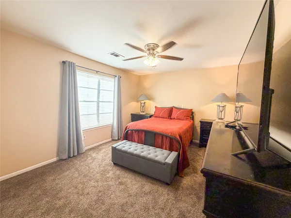 a spacious bedroom with a bed and wooden floor