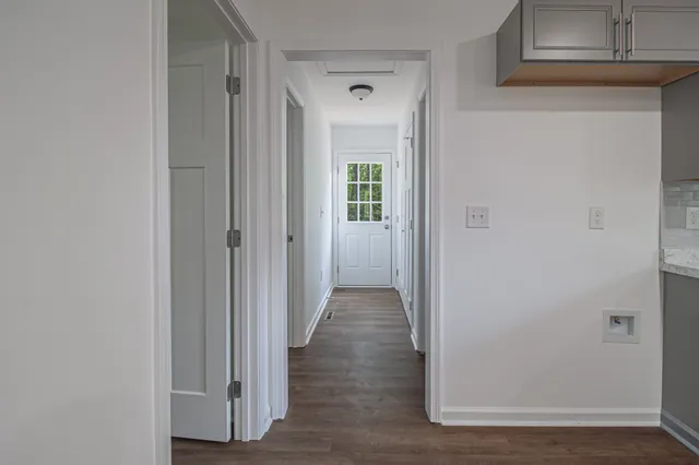 a view of a hallway with wooden floor