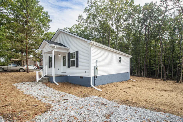 a view of a white house with a yard covered in snow