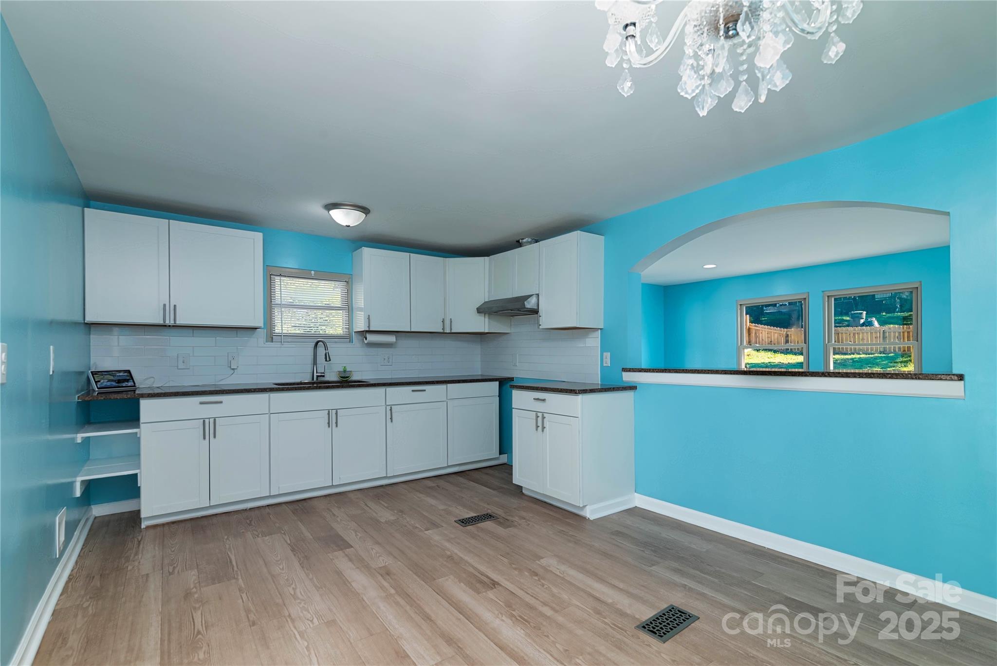 4946 Grand Canyon Road Northwest Concord, NC 28027 - Photo 25 of 40 a kitchen with granite countertop white cabinets a stove a sink and dishwasher
