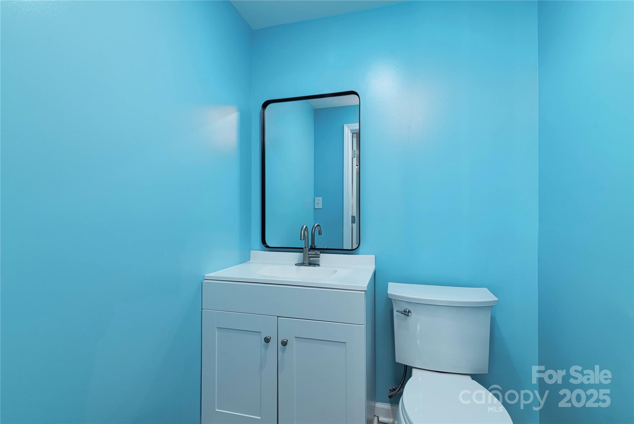 4946 Grand Canyon Road Northwest Concord, NC 28027 - Photo 31 of 40 a bathroom with a toilet a sink and mirror