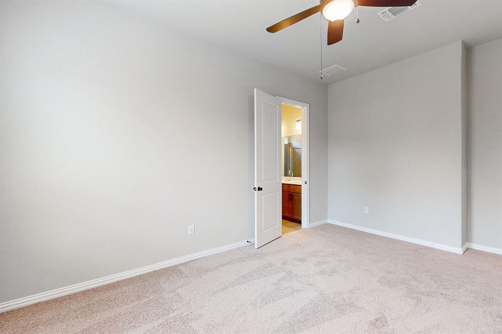 4907 Escape Rivera Drive Austin, TX 78747 - Photo 8 of 28 A spacious bedroom features plush carpeting and a convenient en-suite bathroom access.