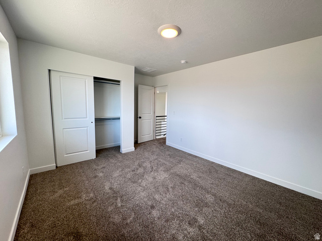 2613 Scarlet Road, Unit 258 Eagle Mountain, UT 84005 - Photo 23 of 33 Carpeted room with a window, white walls, and a built-in closet featuring bi-fold doors