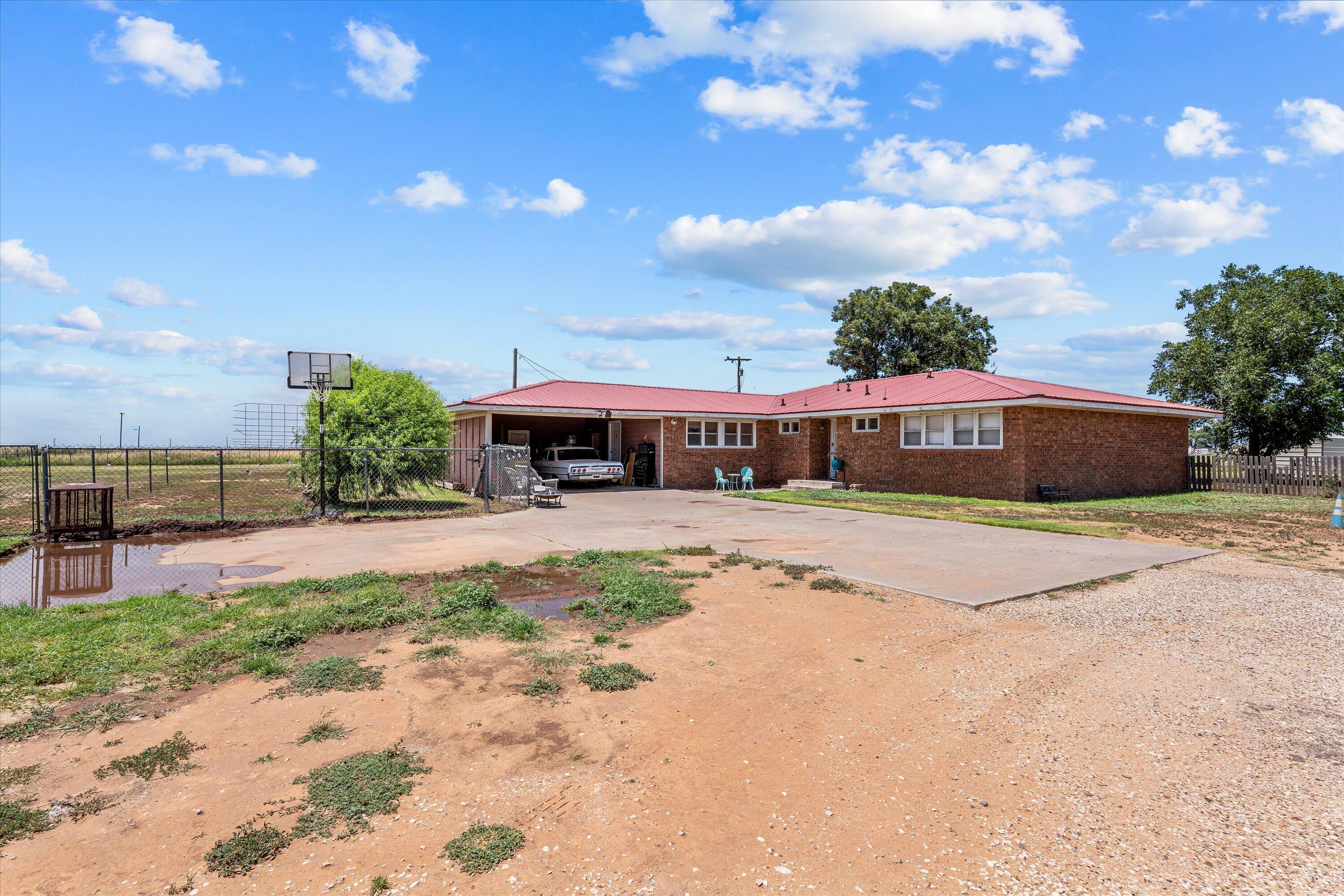 1601 Smith Street Littlefield, TX 79339 - Photo 1 of 32 a front view of a house with a yard and a garage