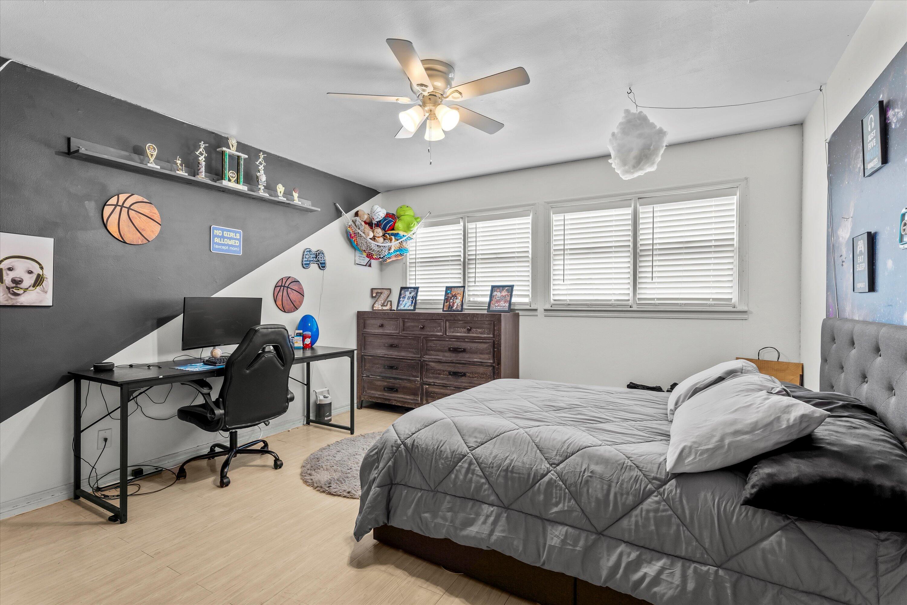 1601 Smith Street Littlefield, TX 79339 - Photo 13 of 32 a bedroom with a bed a desk and chair with a bookshelf