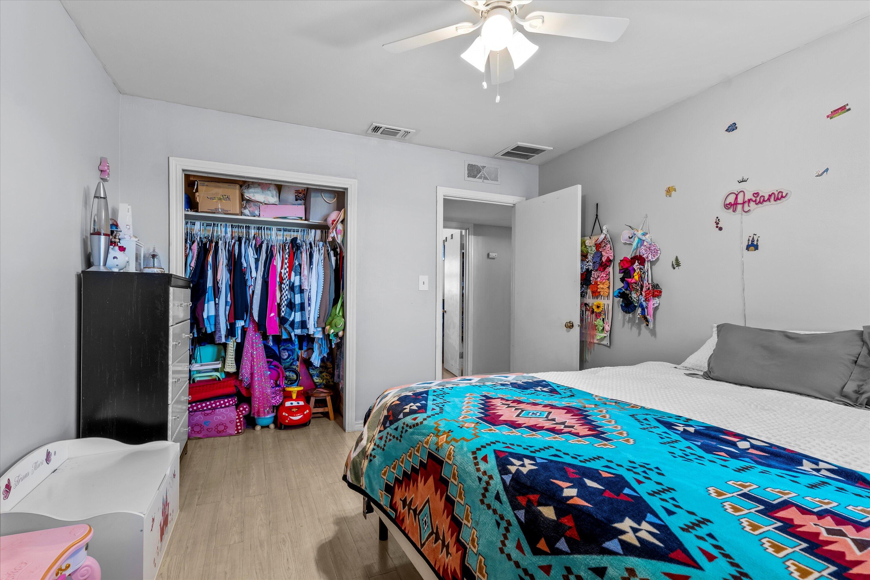 1601 Smith Street Littlefield, TX 79339 - Photo 16 of 32 a bedroom that has a bed and a chandelier
