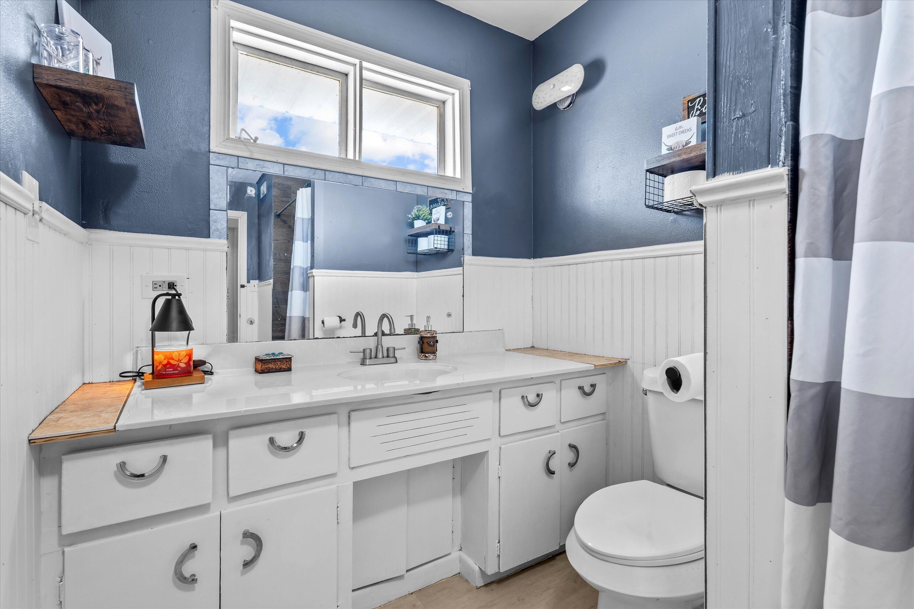 1601 Smith Street Littlefield, TX 79339 - Photo 18 of 32 a bathroom with a toilet sink and mirror