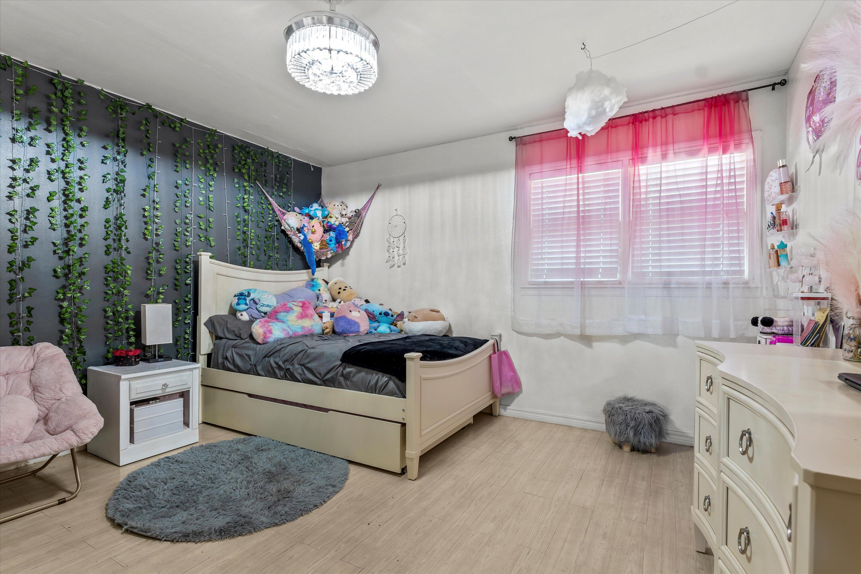 1601 Smith Street Littlefield, TX 79339 - Photo 19 of 32 a bedroom with a bed and a chandelier