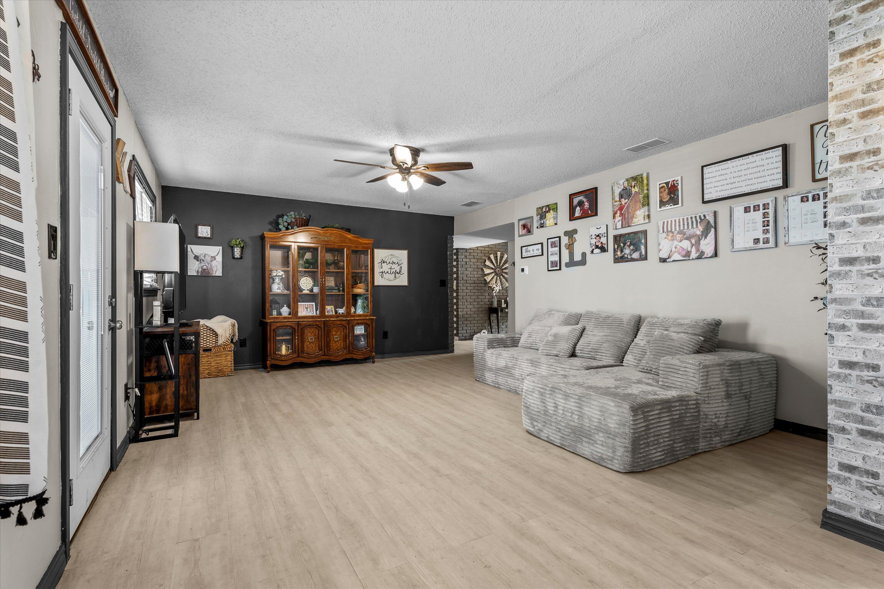 1601 Smith Street Littlefield, TX 79339 - Photo 7 of 32 a living room with furniture and a chandelier