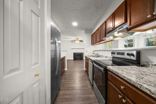a kitchen with stainless steel appliances granite countertop a stove a sink dishwasher and a refrigerator