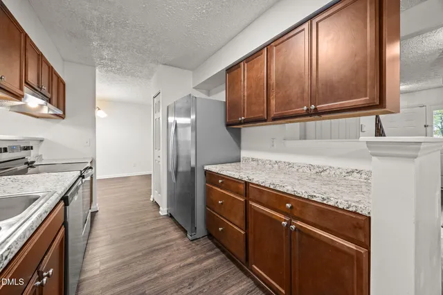 a kitchen with stainless steel appliances granite countertop a stove a sink and a refrigerator