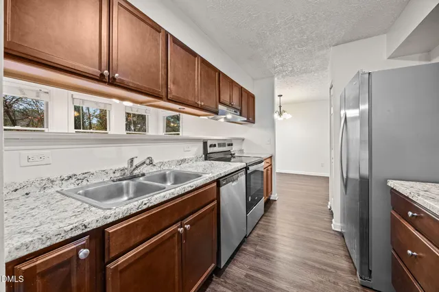 a kitchen with stainless steel appliances granite countertop a sink stove and cabinets