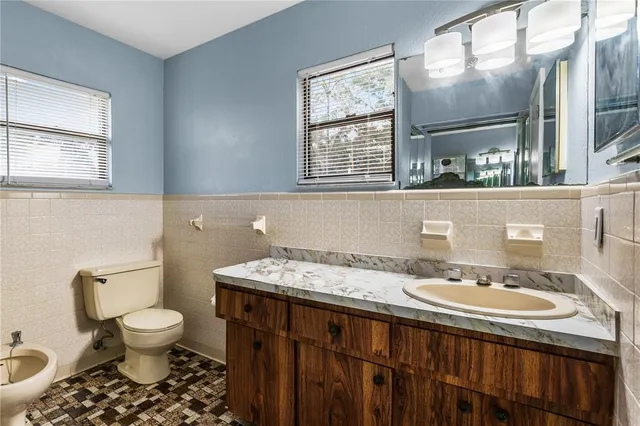 a bathroom with a sink a toilet and a mirror