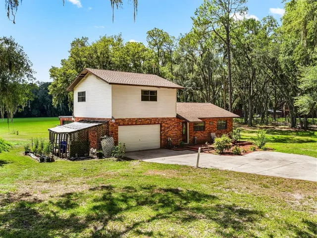 a view of a house with backyard and sitting area