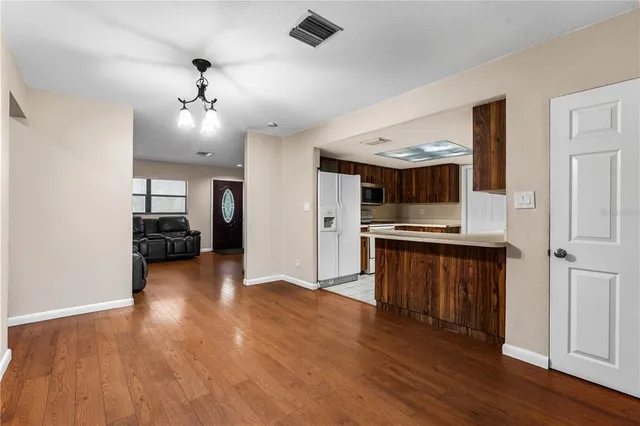 a view of kitchen with sink and refrigerator