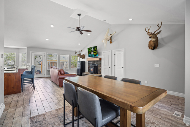 1588 West Rim Rock Drive Stockton, UT 84071 - Photo 7 of 61 Vaulted ceiling with recessed lighting and ceiling fan, wood-finish flooring, stone-faced fireplace with wood mantel, and multiple windows
